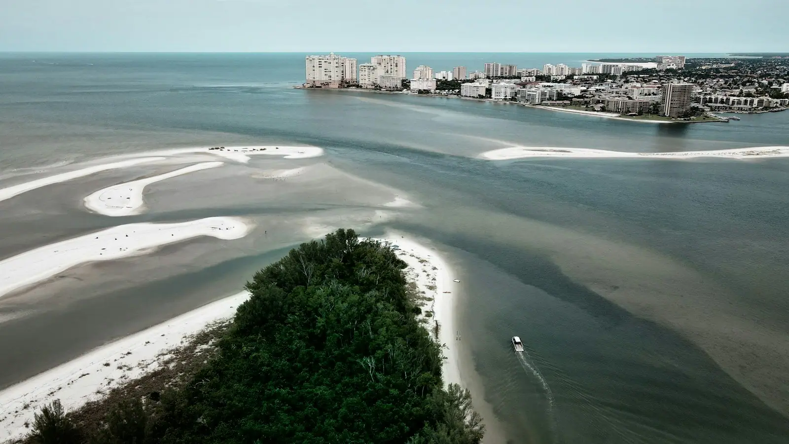 Aerial view of a narrow tidal pass separating two low sandy islands