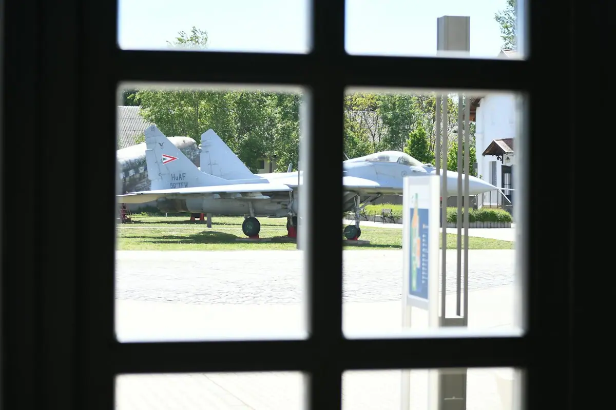 A pair of military jet aircraft on outdoor display under an open sky